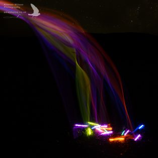 Glow sticks falling like a rainbow waterfall